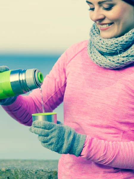 Fit woman in cold day warming up drink tea — Stock Photo, Image