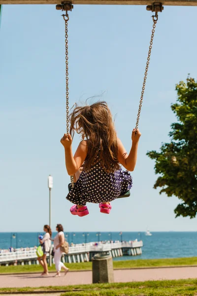 Chica balanceándose en swing-set . — Foto de Stock