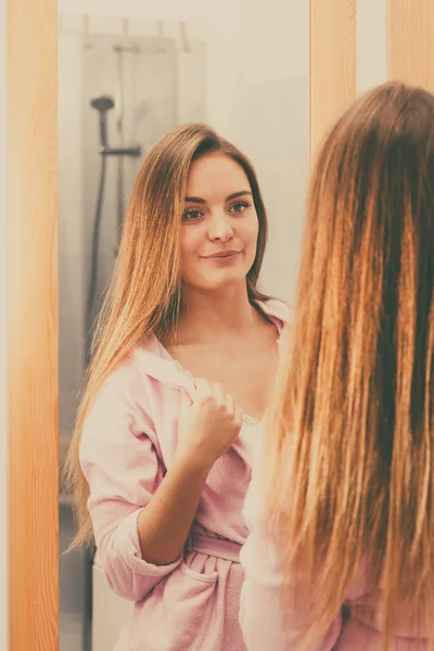 Kvinnan tar hand om hennes långa hår i badrum — Stockfoto