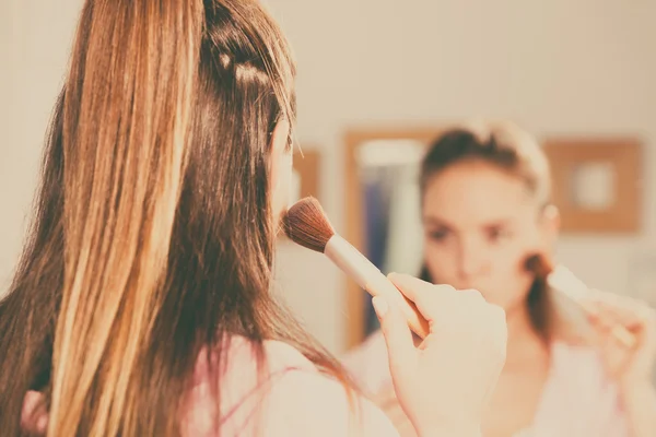 Vrouw bruinen poeder met borstel toe te passen op haar huid — Stockfoto