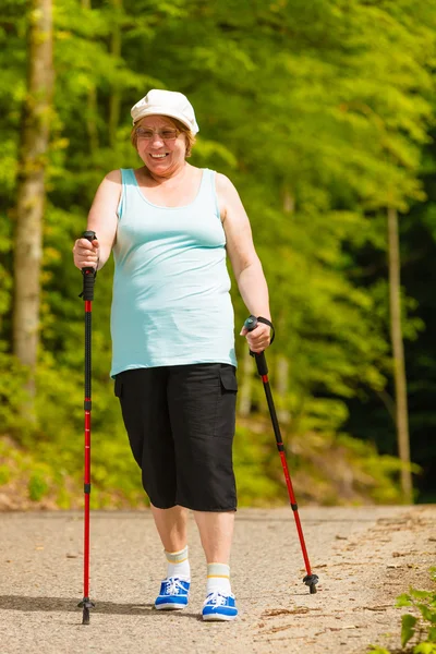 Senior kobieta uprawiania nordic walkingu w parku — Zdjęcie stockowe