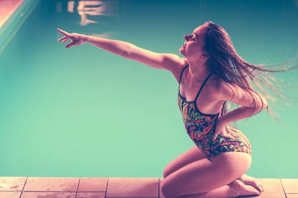 Donna in costume da bagno sedersi ai bordi della piscina vista laterale . — Foto Stock