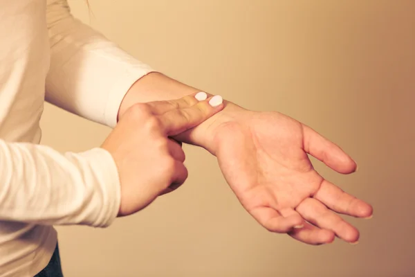 Woman checking pulse on wrist closeup — Stock Photo, Image