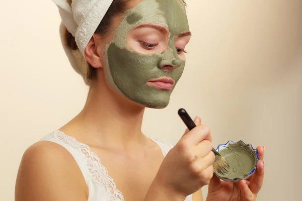 Femme appliquant avec un masque de boue d'argile brosse sur son visage — Photo