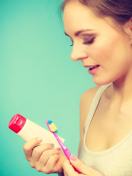 Mujer sostiene cepillo de dientes y pasta para la limpieza de dientes — Foto de Stock