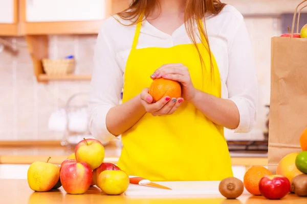 Mulher dona de casa na cozinha com muitos frutos — Fotografia de Stock