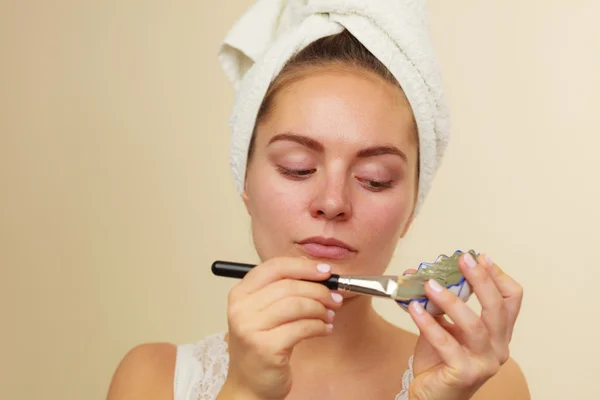 Woman applying with brush clay mud mask to her face — Stock Photo, Image