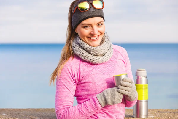 Fit woman in cold day warming up drink tea — Stock Photo, Image