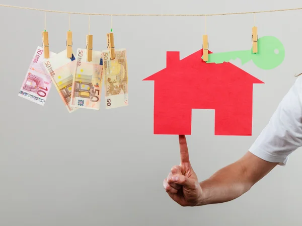 집과 돈을 보여주는 남자 손 — 스톡 사진
