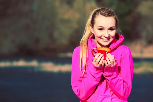 Dziewczyna w parku trzymając kubek. — Zdjęcie stockowe
