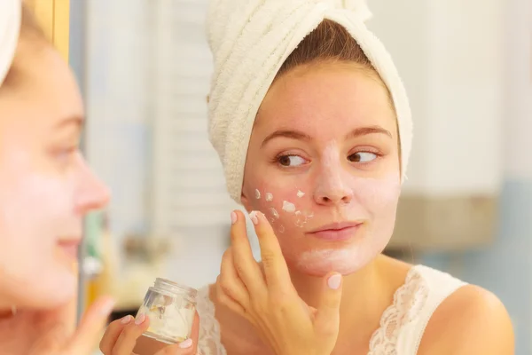 Vrouw masker room toe te passen op gezicht in badkamer — Stockfoto