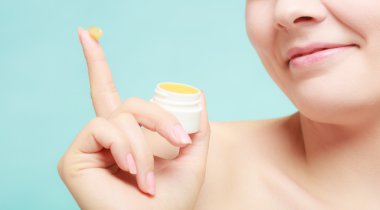 woman applying balsam for lips clipart
