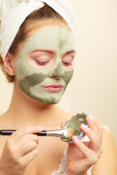 Femme appliquant avec un masque de boue d'argile brosse sur son visage — Photo