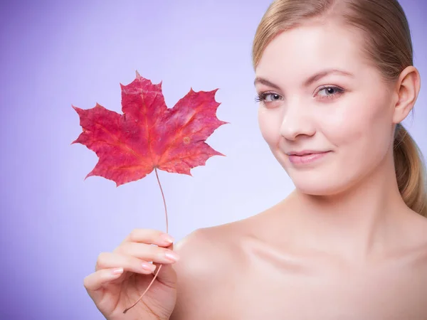 Soins de la peau. Portrait de jeune femme fille avec feuille d'érable rouge. — Photo