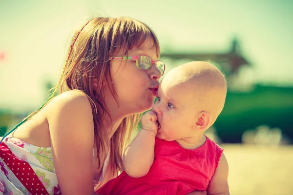 Toddler dziewczynka Całowanie siostry na słoneczny dzień — Zdjęcie stockowe