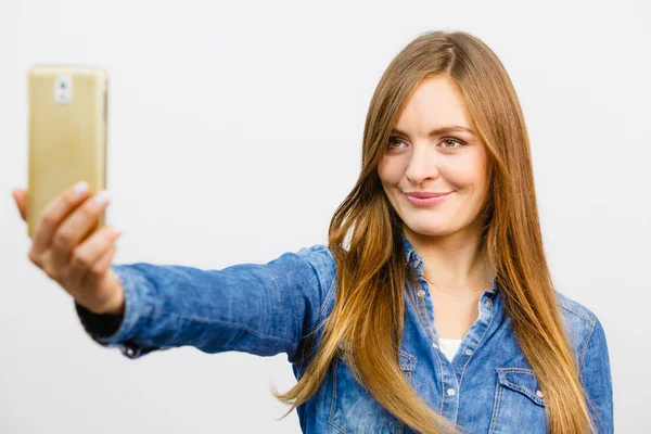 Mujer en camisa de mezclilla tomando auto foto con el teléfono —  Fotos de Stock