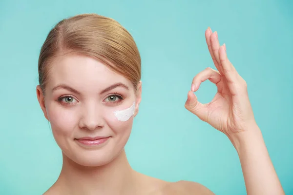 Vrouw aanbrengen crème op haar huid gezicht. — Stockfoto