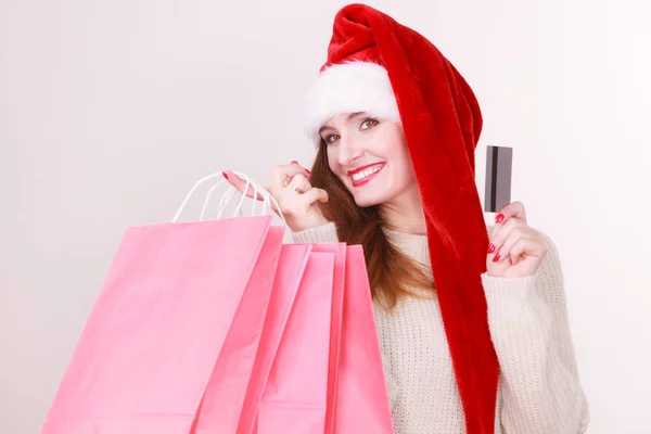 Mujer en sombrero de Navidad tiene tarjetas de crédito y bolsas de compras . — Foto de Stock