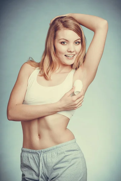 Flicka tillämpa stick deodorant i armhålan. — Stockfoto