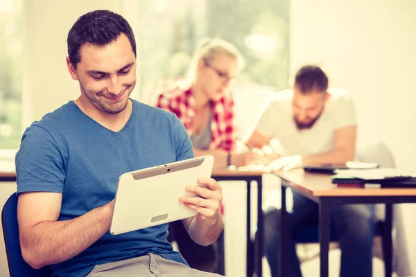 Mannelijke student met tablet voor haar klasgenoten — Stockfoto