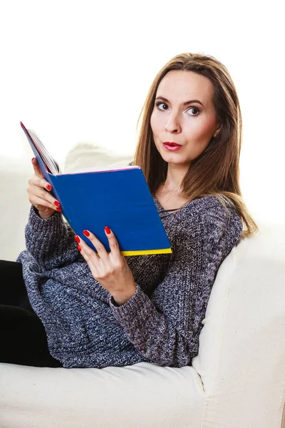 Woman sitting on couch reading book at home — Stock Photo, Image