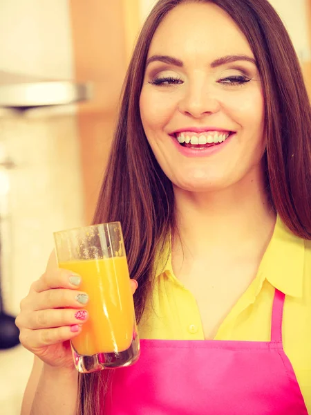 Femme dans la cuisine boire du jus d'orange frais — Photo