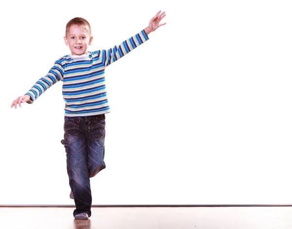 Mały chłopiec bawić się samodzielnie w domu stoją na jednej nodze. — Zdjęcie stockowe