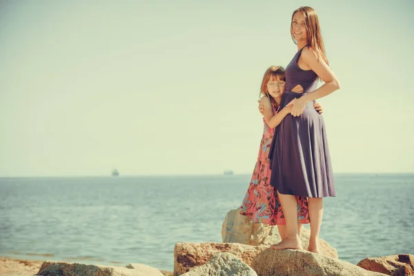 Matka i córka pozowanie na morzu skały — Zdjęcie stockowe
