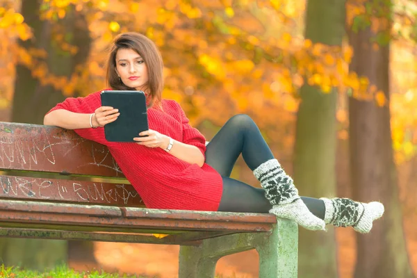 Mujer en el banco en el parque con la tableta . — Foto de Stock