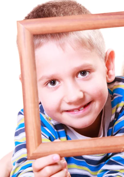 Kleiner Junge spielt mit leerem Rahmen. — Stockfoto