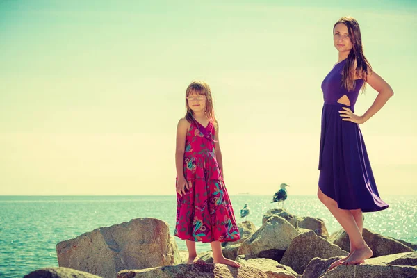 Mère et fille posant sur des rochers marins — Photo