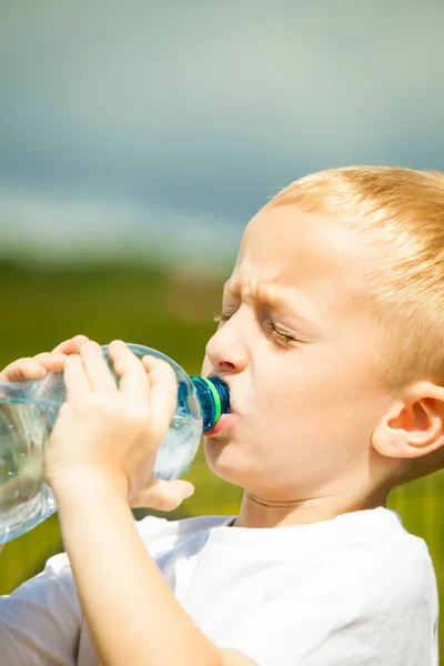Menino bebe água da garrafa, ao ar livre — Fotografia de Stock
