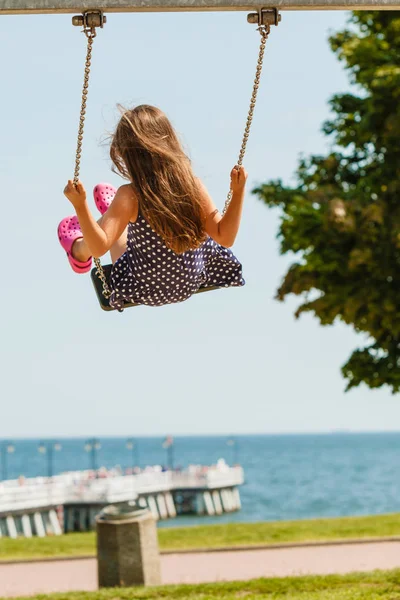 Chica balanceándose en swing-set . — Foto de Stock