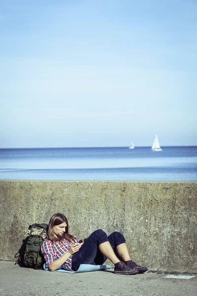 Uomo turista zaino in spalla seduto con tablet esterno — Foto Stock