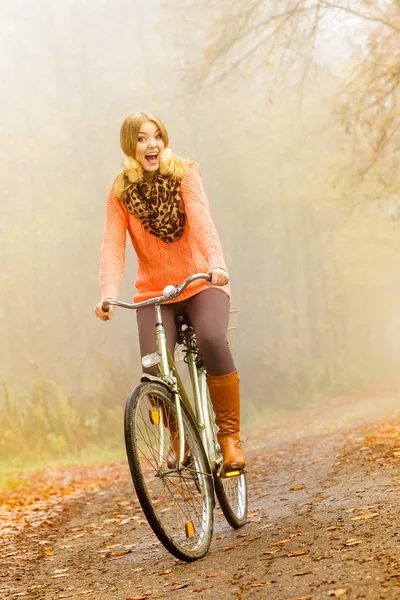 Happy active woman riding bike in autumn park. — Stock Photo, Image