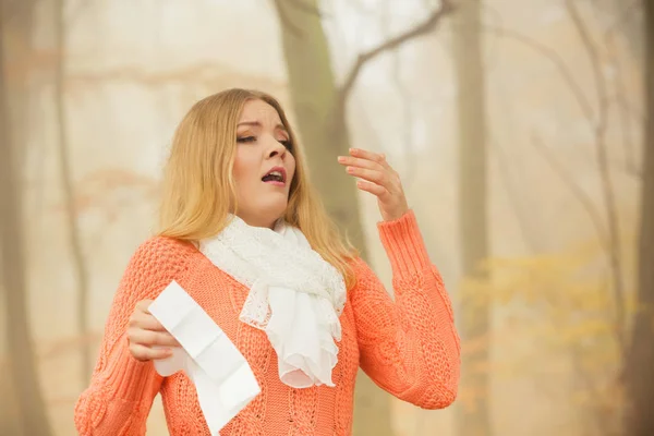 Malade femme dans le parc d'automne éternuer dans les tissus . — Photo