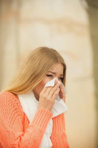 Sick ill woman in autumn park sneezing in tissue. — Stock Photo, Image