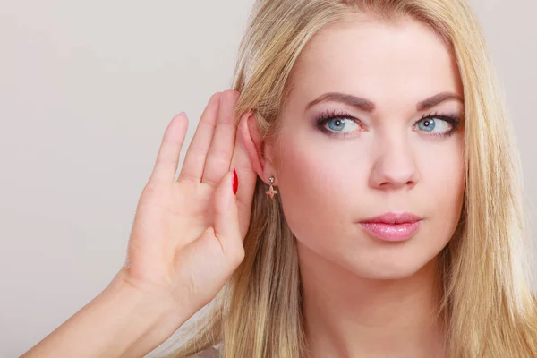 Gossip girl with hand behind ear spying — Stock Photo, Image