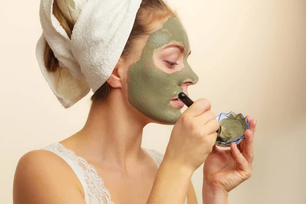 Femme appliquant avec un masque de boue d'argile brosse sur son visage — Photo