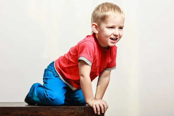 Kleiner Junge spielt auf Tisch sitzen. — Stockfoto