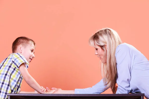 Mother and son arm wrestle sit at table. — Stock Photo, Image