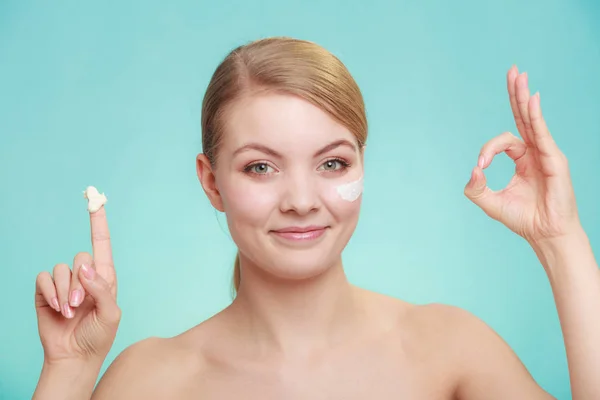 Mulher aplicando creme no rosto da pele . — Fotografia de Stock