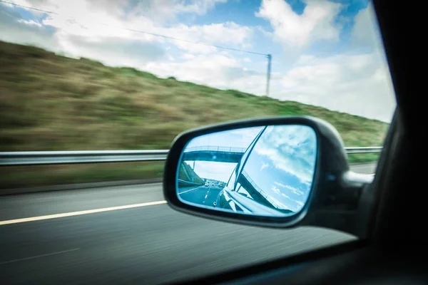 Coche en la carretera y espejo retrovisor — Foto de Stock