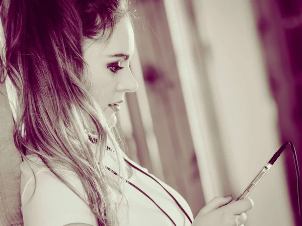 Женщина в наушниках выбирает музыку на смартфоне . — стоковое фото