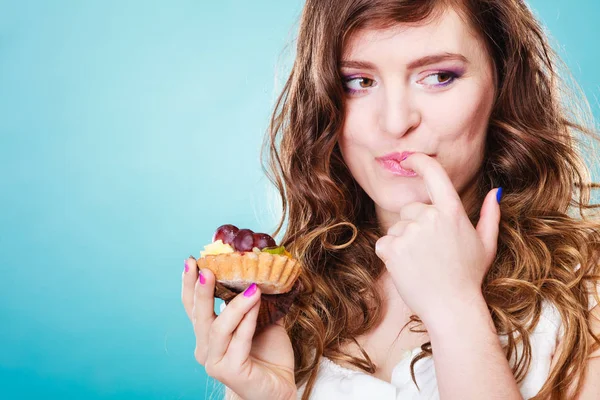 Souriant femme mignonne tient gâteau aux fruits dans la main — Photo