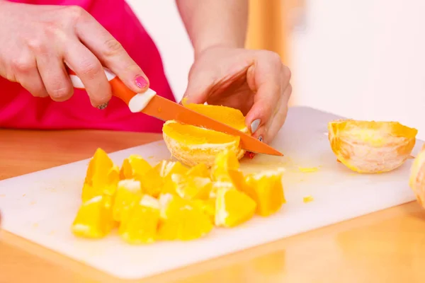 Mujer ama de casa en cocina corte de frutas naranja —  Fotos de Stock