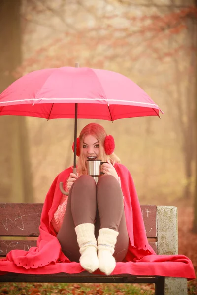 Mujer con taza y paraguas en el banco —  Fotos de Stock
