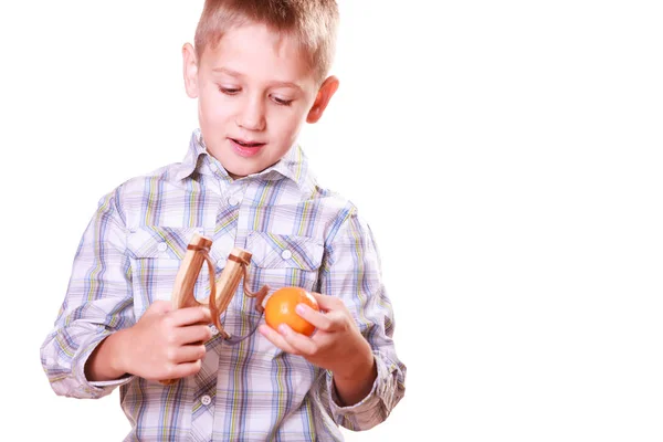 Young boy use sling shot shoot mandarine. — Stock Photo, Image