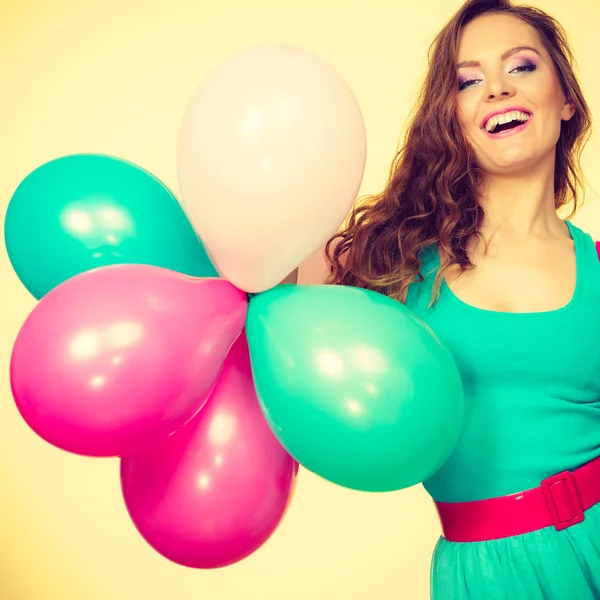 Mujer sosteniendo racimo de globos de colores — Foto de Stock