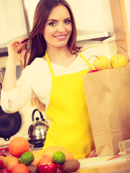 Femme au foyer dans la cuisine avec de nombreux fruits — Photo